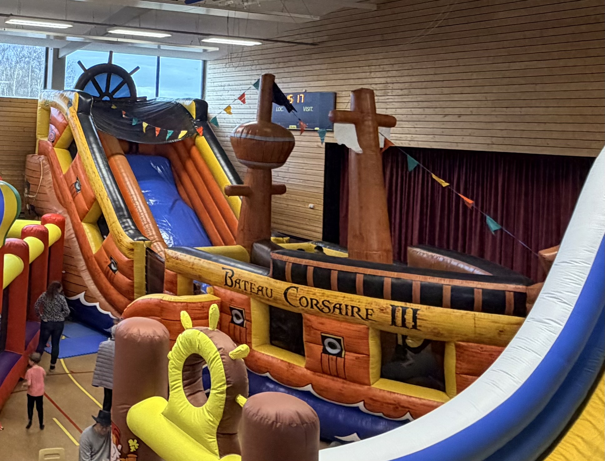 Grand bateau pirate gonflable Corsaire III avec deux m&acirc;ts, gouvernail et toboggan dans la salle polyvalente d'Eschbach