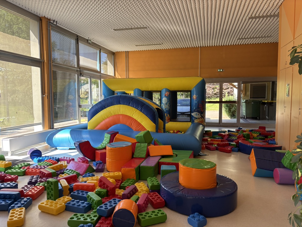 Espace petite enfance avec structure gonflable, briques géantes et jeux en mousse