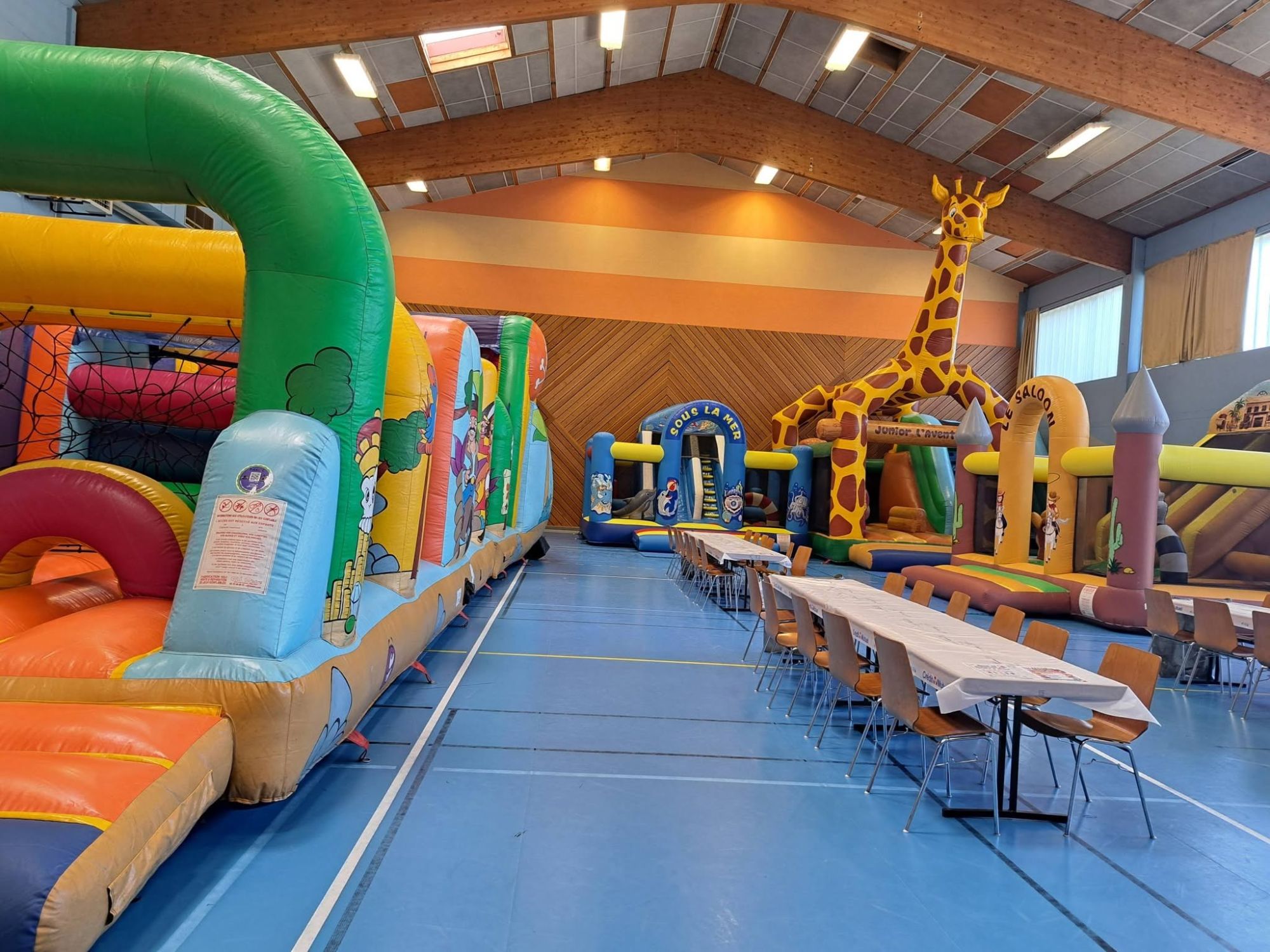 Salle de l&rsquo;Escale avec le Parcours Pirate au premier plan, des tables au centre et le Complexe Girafe au fond